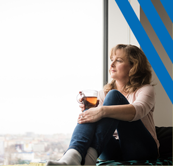 women holding a mug looking at a window