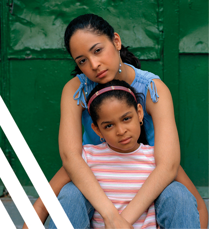 Young woman arms around girl, green background